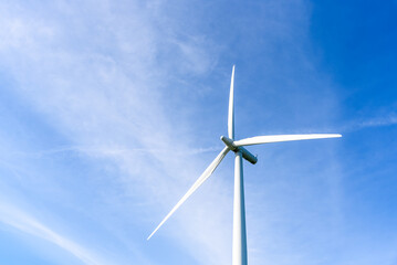 Detail of wind turbine against blue sky with clouds on a sunny autumn day