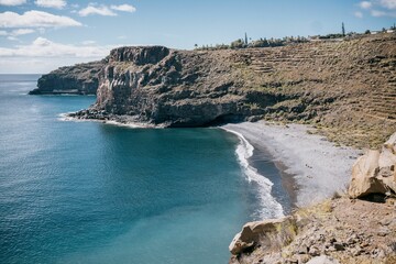 Rocky cliffs overlook over a secluded beach and ocean area, La Gomera, Canary Islands, Spain