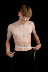 Teenage boy measuring his waist