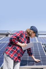 Woman with digital tablet touching solar panel