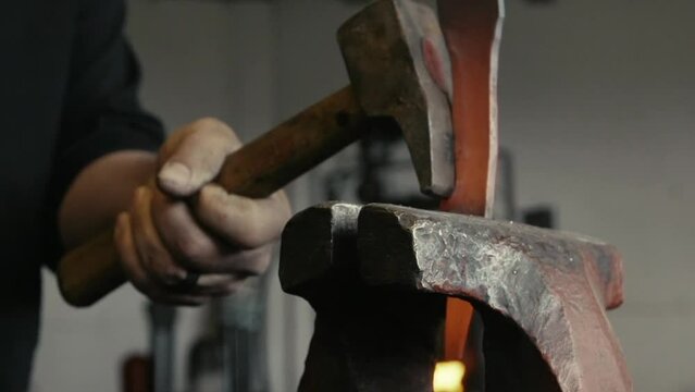 Closeup shot of a blacksmith working with metal in his workshop