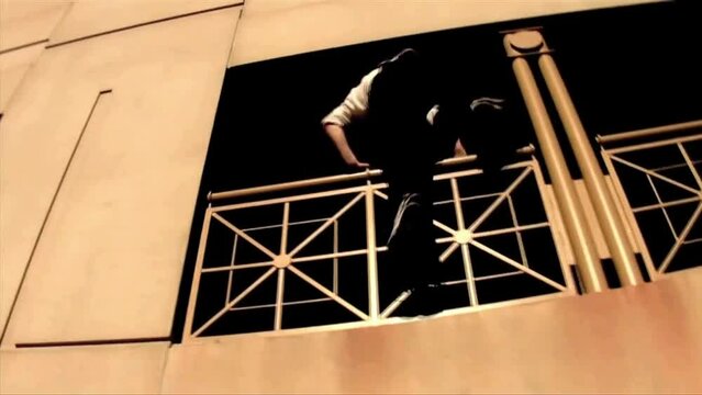 Young skillful traceur climbing, jumping, and running in the street