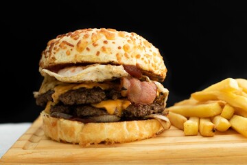 Delicious cheeseburger and french fries displayed on a cutting board.