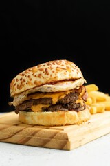 Delicious cheeseburger and french fries displayed on a cutting board.