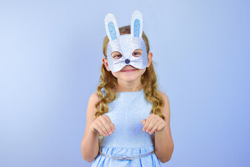 A child in a masquerade carnival mask of a hare or a rabbit, made by hand from shiny glitter foamiran and sequins. Masquerade, Carnival, Party, Holiday, Birthday