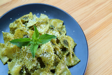 Delectable Bow-tie Pasta or Farfalle in Pesto Sauce Served on Wooden Table