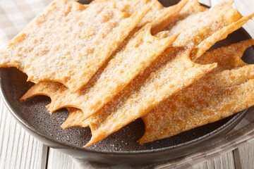 Crispy French holiday fritters Oreillette close-up in a plate on the table. horizontal