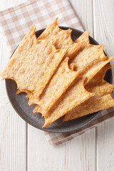 Oreillettes or Chiacchiere is a traditional dessert usually sold during holidays in Italy and in France at Christmas as well as Carnival closeup on the plate. Vertical top view from above