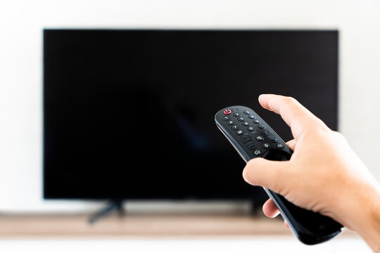 Hand holding remote control for turn off TV