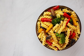Homemade Garlic Veggie Rotini Pasta in a Bowl on a gray background, top view. Flat lay, overhead, from above.