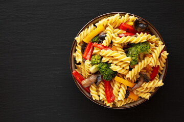 Homemade Garlic Veggie Rotini Pasta in a Bowl on a black background, top view. Flat lay, overhead,...