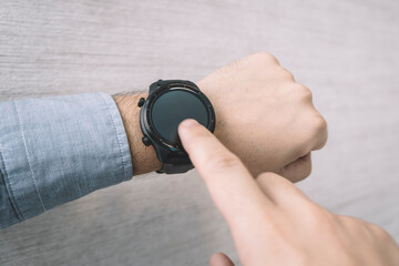 Fototapeta premium Fitness watch on mans forearm showing date, time, heart rate step counter.