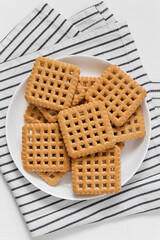 Sweet crunchy square cookies on a plate.