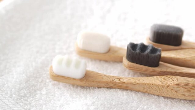 Bamboo toothbrushes with gray and white soft bristles. A set of eco-friendly toiletries. Natural dental health, beauty treatments, zero waste concept. Selective focus.
