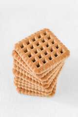 A stack of crispy square biscuits on a white background. Copy space.