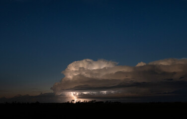 Thunderstorm and lightning under a starry sky