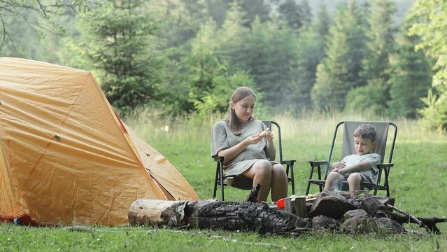 Mother uses a remedy for mosquitoes and biting insects in nature for son. Protection of the skin from tick bites, gadflies, blood-sucking pests, a means for children without allergens for outdoor camp