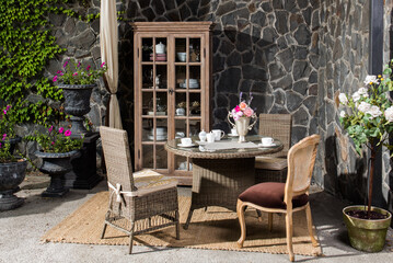 a served table and chairs made of rattan furniture on the veranda