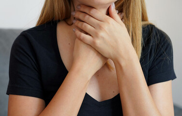 Sore Throat. Close-up of beautiful woman with hands on neck. Concept of sore throat, pharyngitis,...