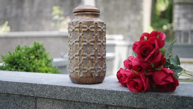 the cremation urn and the ceremony of scattering the ashes on the background of the cemetery