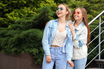 Fototapeta premium Young sisters walking on city street