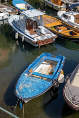 Fototapeta na wymiar An old blue boat in a small harbor