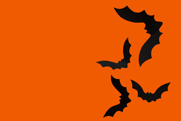 Paper bats for Halloween party on orange background