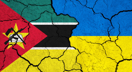 Flags of Mozambique and Ukraine on cracked surface - politics, relationship concept