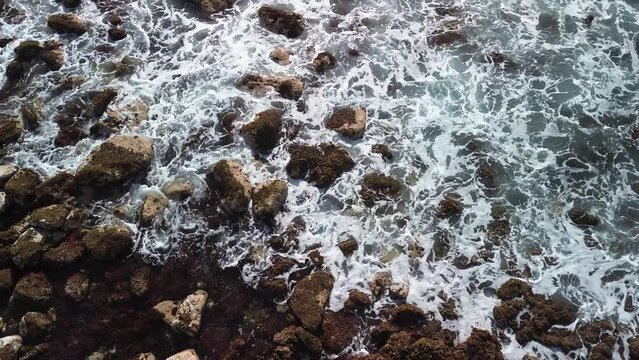 Pequenas ondas do mar sobre pedras vulc&acirc;nicas. 