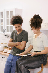 couple man woman are sitting on table in kitchen paying electricity and rent bills. African...