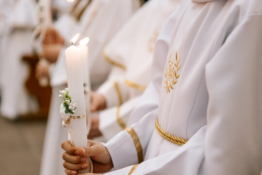 photo of children's hands receiving their first communion in a Catholic church, the priest blesses them