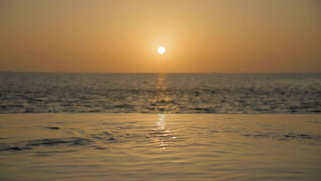 Couple entering private pool at sunset and kissing