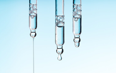 Set pipette serum drop with clear liquid niacinamide, hyaluronic or Aha Bha acids on a blue white...