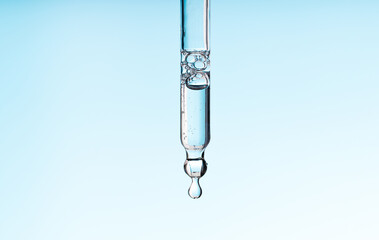 Pipette serum with clear liquid niacinamide, hyaluronic or Aha Bha acids on a blue white isolated...