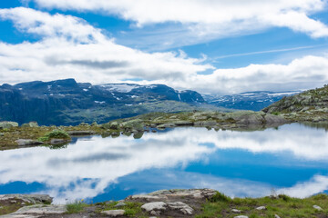 Amazing reflection over a lake in the mountains of Trolltunga hike,  Norway