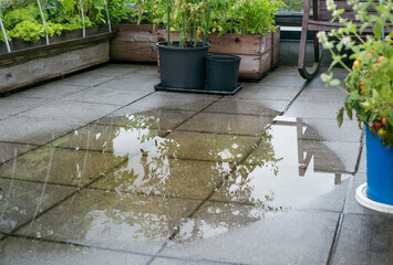 Patio drain clogged and flooded after heavy rain. Overflown drainage causing to pool large amount...