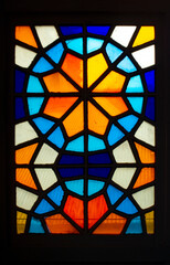 Vertical photo. Colored glass in form of flowers in metal frame. Window with stained glass. Multicolored Pattern. Kaleidoscope. Concept of repeating pattern, preservation of antiquity. Mosaic pattern