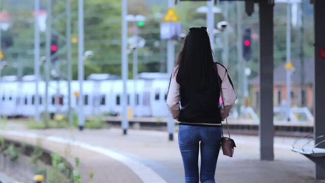 Pretty Asian Woman walking along the platform at a train station - people photography