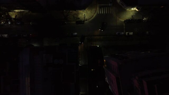 Night, a car drives into the garage from the street, and another car makes a parallel parking, shooting from a drone