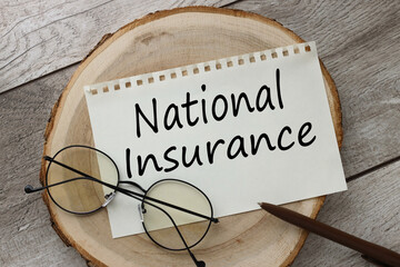 National Insurance torn paper with text. wooden background