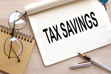 top view of Tax Savings text. on a wooden table. purple stickers