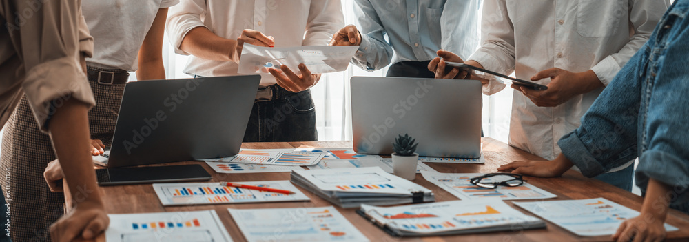 Leinwandbilder Analyst team utilizing BI Fintech to analyze and pointing at financial dashboard paper office. Businesspeople examining report paper on table for business insight. Panorama shot. Scrutinize