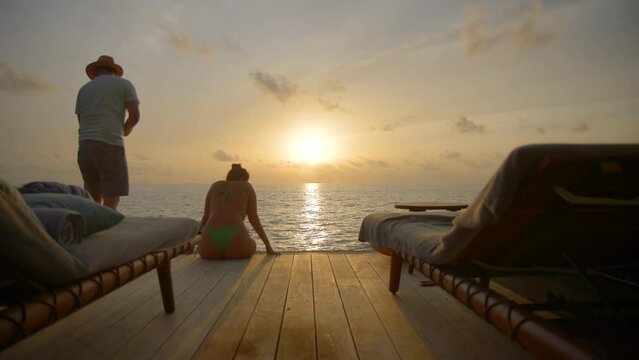 Couple enjoying sunset and kissing on luxury vacation