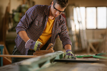 Young male carpenter working in a carpenter shop