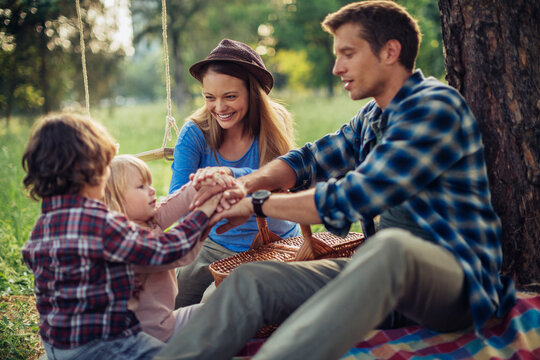 Young family having a picnic on a field in the forest
