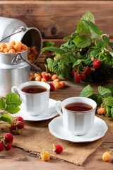 Cup of tasty raspberry tea on wooden table. Useful drink for health. Herbal tea. Traditional medicine.