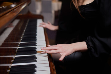 Fototapeta na wymiar Close up of young girls hands, playing piano.