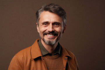 Obraz premium Caucasian mid adult man smiling on a brown background