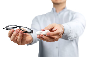 Male hands offering a choice between eyeglasses and contact lens, cut out