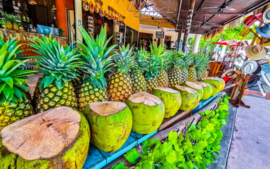 Tropical fruit stall with pineapple and coconut in Tulum Mexico.